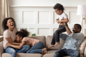 Happy black family enjoying time together on the couch. If you're struggling right now in your family and miss the way your family used to bond, family therapy and counseling for kids may be the place to begin. Whole journey wellness wants you to enjoy time with your family and work through the stressors you're dealing with. Begin counseling with us today!