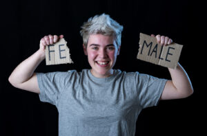 Happy young teen with broken sign staying female. You don't have to live by societies standards of norm. Our LGBTQIA+ friendly therapists will support your journey. Begin LGBTQIA+ counseling in North Carolina and Virginia with us!